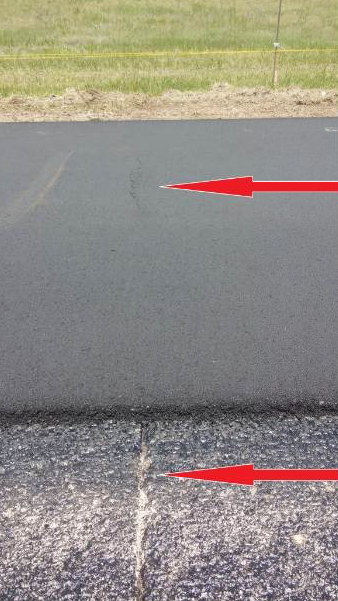 Afternoon rain storms had been a common event leading up to the paving date for this I-70 project in Colorado. The existing concrete surface was saturated where water had infiltrated the expansion joints, shown by the lower arrow here. During mix production, results of the material tests varied, and during placement of the new asphalt pavement, compaction proved difficult. Moisture was at the root of the problem where the mat was shoved under the roller drums, which caused the cracking shown by the upper arrow here. The crew resolved the issue by testing the asphalt mix until they had it right and consistent.