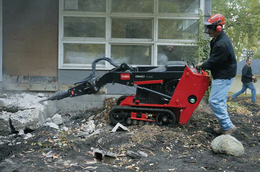 The Toro Dingo multi-position mounting head allows the operator to break in horizontal and vertical positions. The standard, conical tool bit breaks down to a 10-inch depth, according to the manufacturer. There are other bits available such as line, chisel, moil, etc. Photo courtesy Chicago Pneumatic.