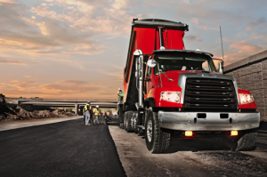 A Freightliner 114SD haul truck charges the hopper with mix, delivered on-time thanks to Detroit Connect Virtual Technician monitoring for optimum uptime.