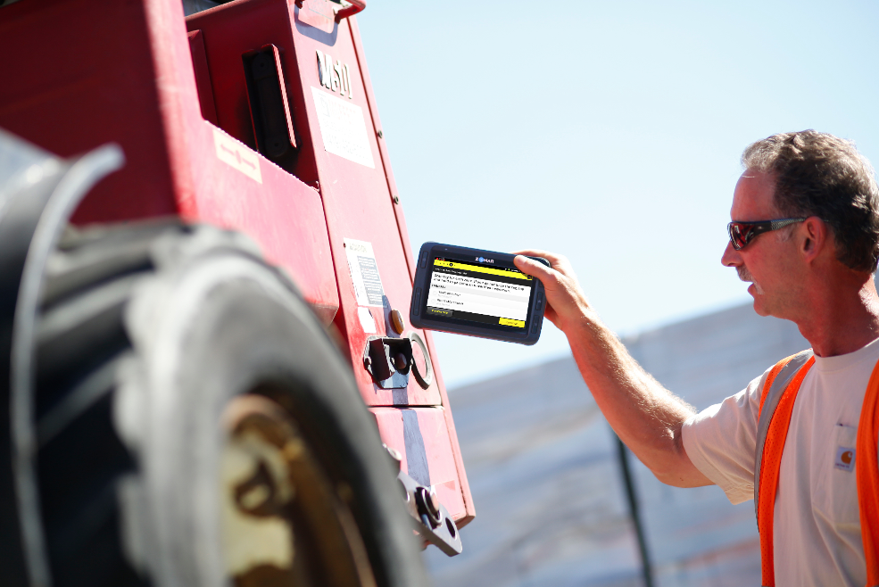 This worker holds the EVIR pad near an RFID tag on a forklift.