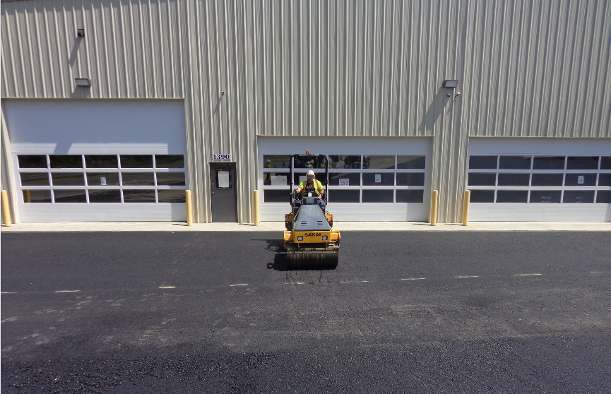 Once the east-west lanes of the mat in front of the building at the low end of the parking lot had solid and excellent compaction, the roller operator could line up to roll onto the north-south lanes with no worries about moving across the v-joint.