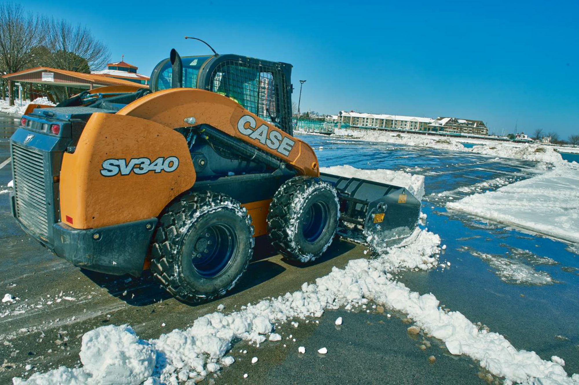 The contractor is able to use less deicing material on the porous asphalt pavement, and expend less energy plowing the surface. Photo courtesy CASE Construction Equipment.