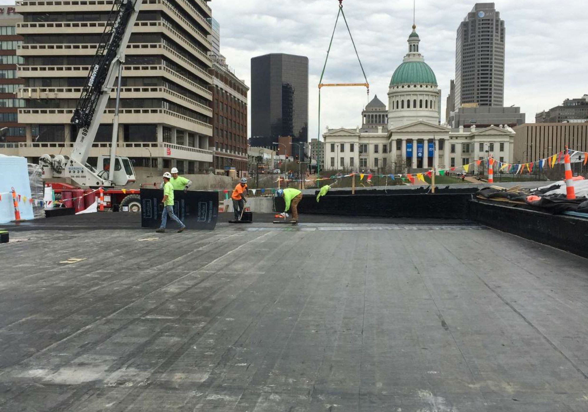 Both layers of the Laurenco modified bitumen sheet waterproofing have been installed here. Western workers apply a third and final coat of adhesive before placing the 1/8-inch asphalt protection board on top of the adhesive.