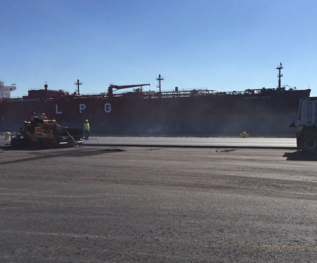 Here you can see the Gulf Coast crew placing the surface course atop a good-looking binder course, which is already compacted and set for the structural integrity required of this port. Heavy loads on turning wheels will abuse this pavement for years to come.