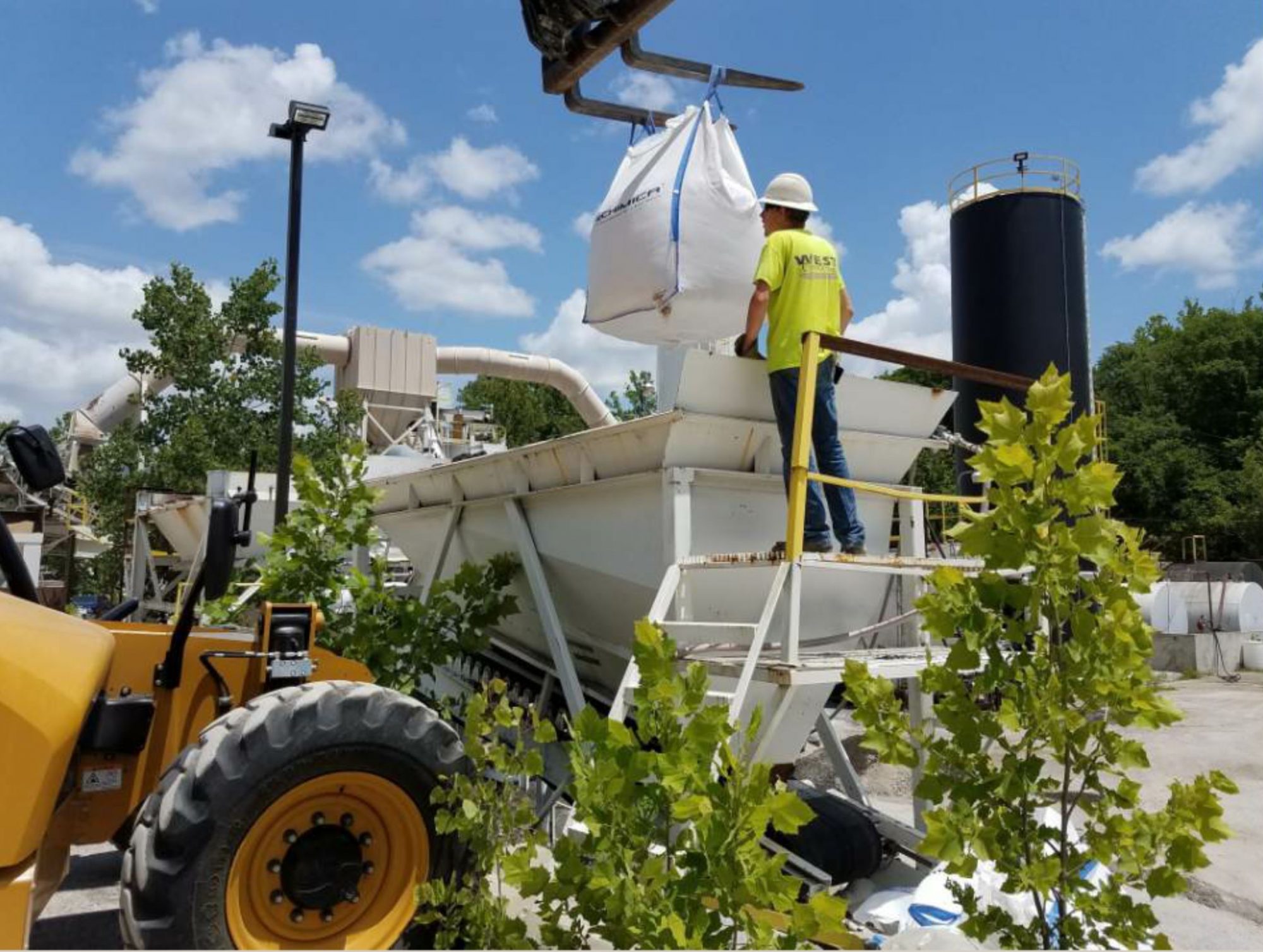 Personnel used the tines of a fork lift to hold the totes over the RAS bin, which metered the material into the mix at a target rate of 5 percent of total weight.